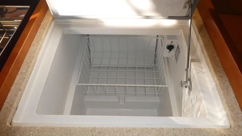 Slide: The Image of Beneteau Oceanis 41 (2014) yacht refrigerator with open lid and wire basket inside. - 20