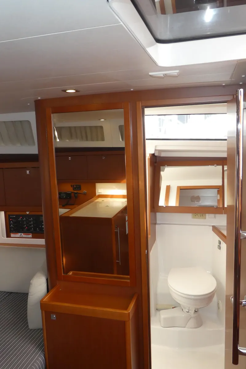 Slide: The Image of Interior of 2014 Beneteau Oceanis 41 yacht, featuring a compact bathroom and wooden cabinetry. - 30