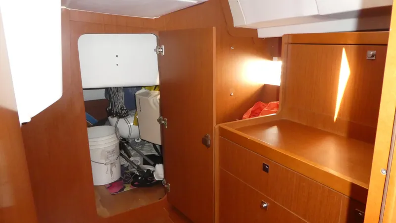 Slide: The Image of Interior of 2014 Beneteau Oceanis 41 sailboat with wooden cabinetry and storage area. - 33