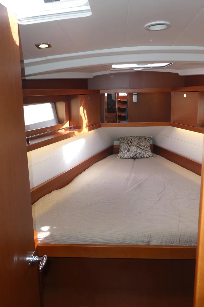 Slide: The Image of 2014 Beneteau Oceanis 41 cabin interior with bed, wooden finish, and natural light. - 34