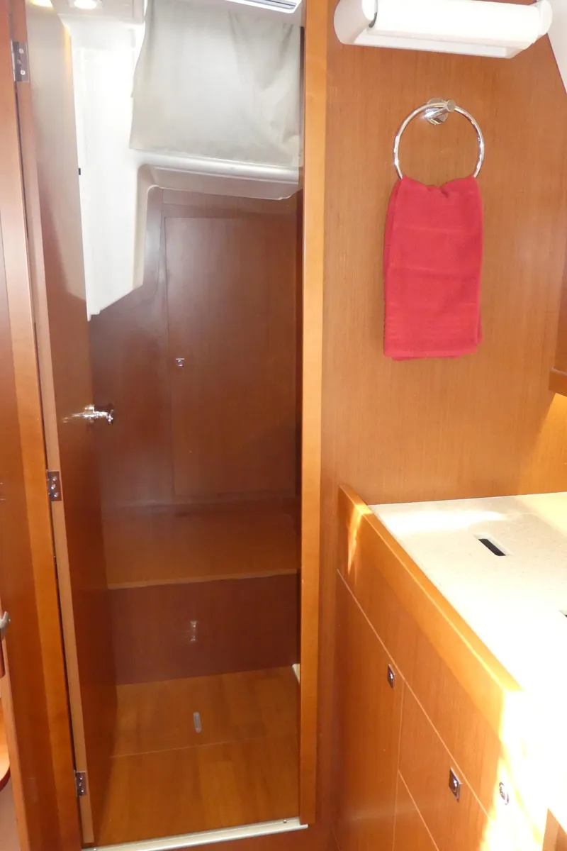 Slide: The Image of Interior of 2014 Beneteau Oceanis 41 yacht, featuring wooden cabinetry and a red towel. - 46