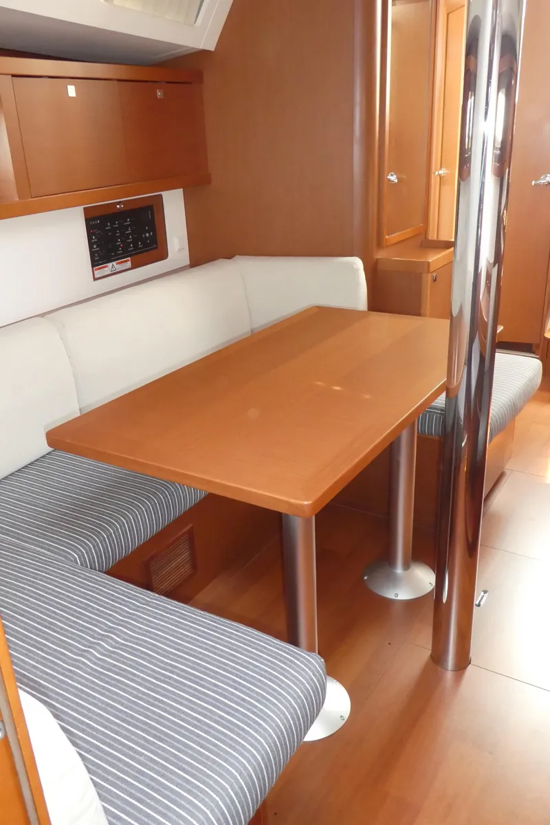 Slide: The Image of Interior of 2014 Beneteau Oceanis 41 sailboat with dining area and wooden table. - 9