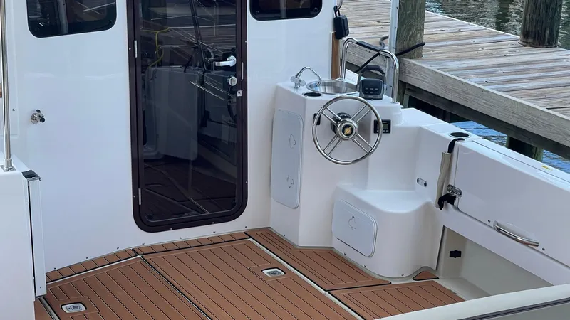 Slide: The Image of 2025 Ranger Tugs R-31 CB boat cockpit with teak flooring and steering wheel. - 3