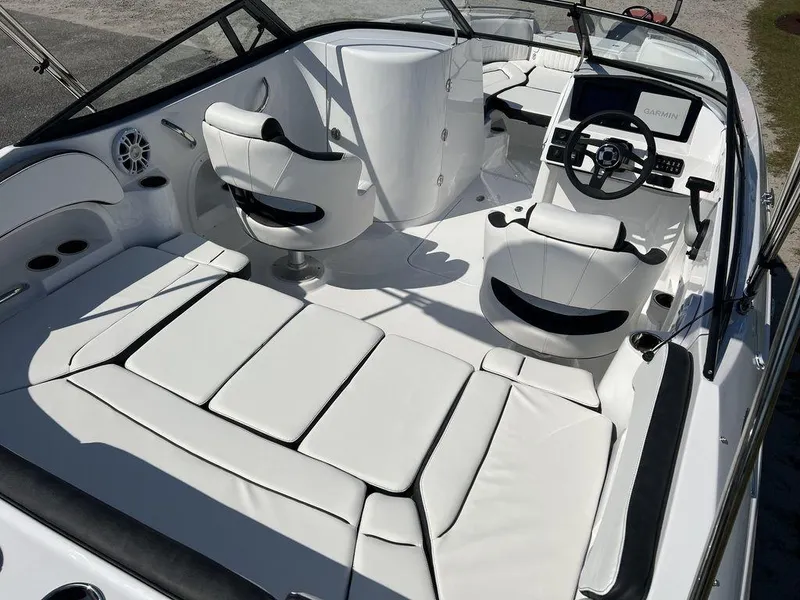 Slide: The Image of 2025 Stingray 211DC boat interior with white seating and modern dashboard. - 13