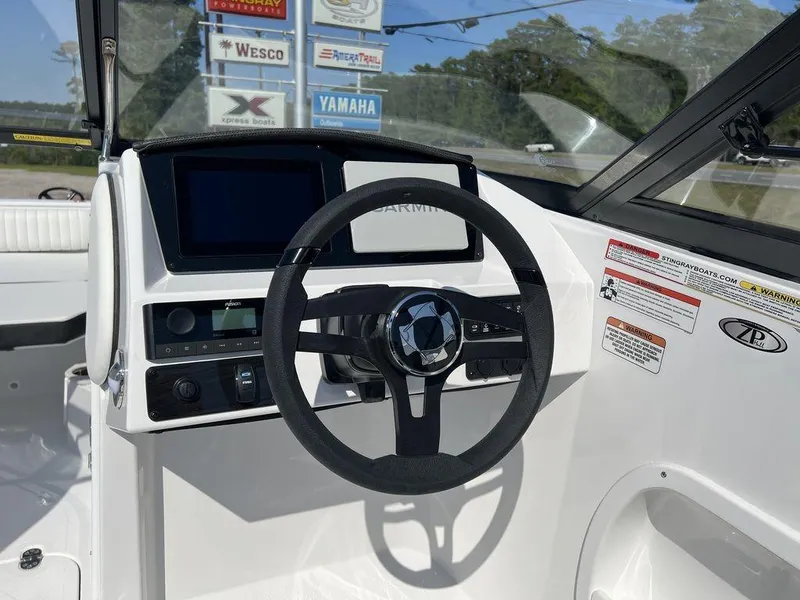 Slide: The Image of 2025 Stingray 211DC boat dashboard with steering wheel and digital display. - 14