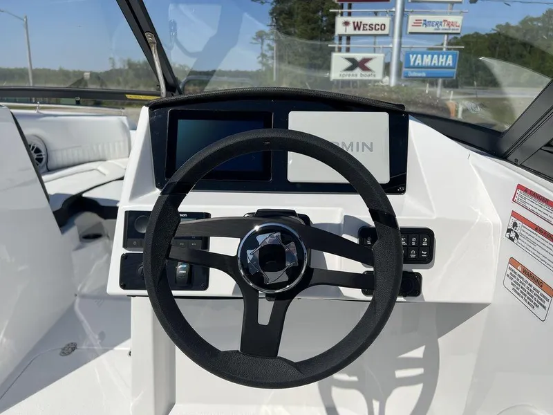 Slide: The Image of 2025 Stingray 211DC boat dashboard with steering wheel and Garmin display. - 15