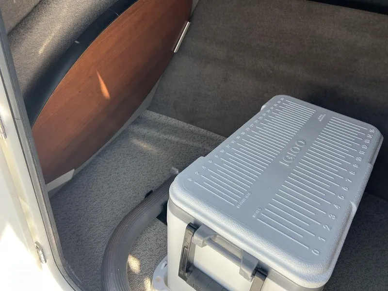 Slide: The Image of Storage compartment in 2025 Stingray 211DC boat with cooler and wooden panel. - 18