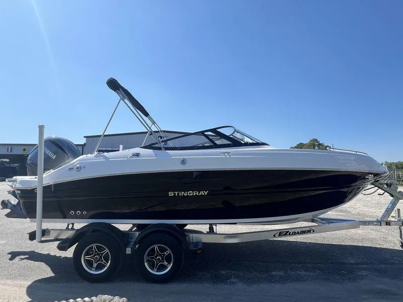 Slide: The Image of 2025 Stingray 211DC boat on trailer, black and white design, sunny day. - 4