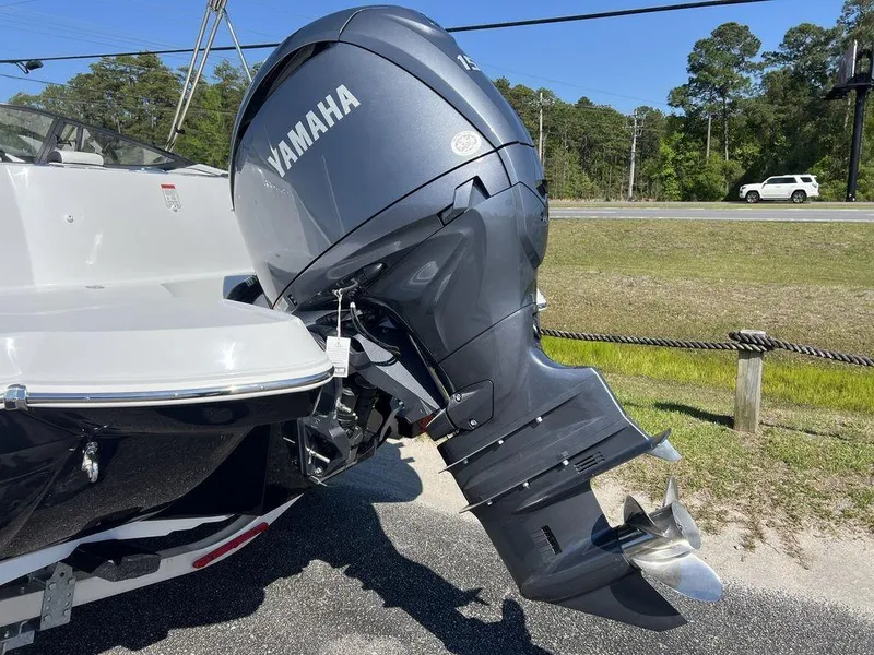 Slide: The Image of 2025 Stingray 211DC boat with Yamaha outboard motor, parked outdoors. - 9