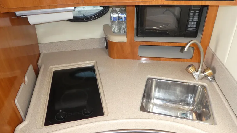 Slide: The Image of 2004 Larson 370 yacht kitchen with sink, stove, and microwave. - 21