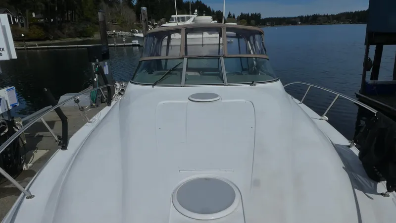 Slide: The Image of 2004 Larson 370 boat docked at a serene marina, showcasing its sleek design. - 34