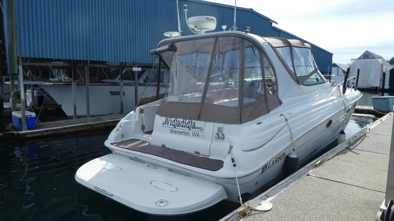 Slide: The Image of 2004 Larson 370 boat docked at marina with blue building in background. - 4