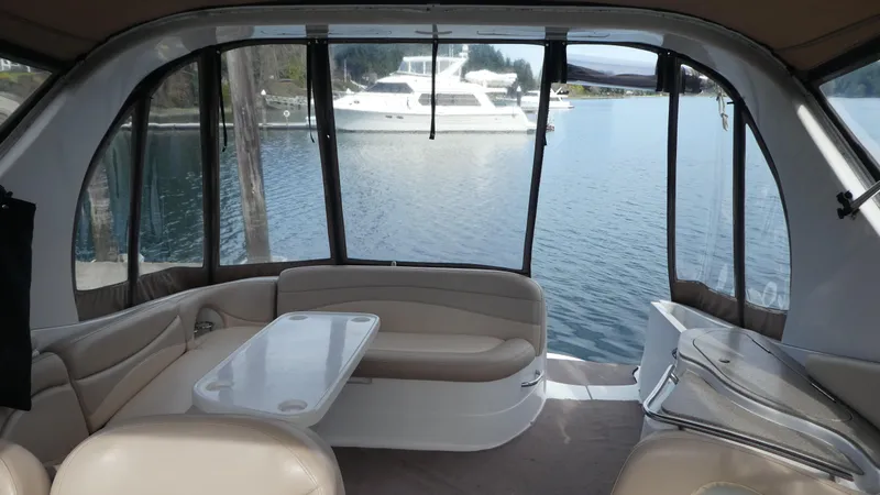 Slide: The Image of Interior of 2004 Larson 370 boat with seating and table, overlooking a serene lake view. - 6