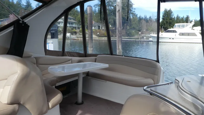 Slide: The Image of Interior of 2004 Larson 370 boat with beige seating and waterfront view. - 7