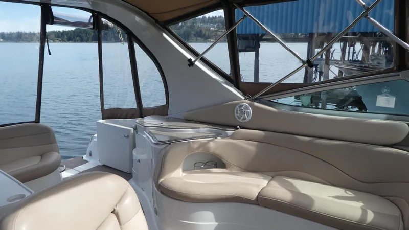 Slide: The Image of Interior view of a 2004 Larson 370 boat with beige seating and lake backdrop. - 8