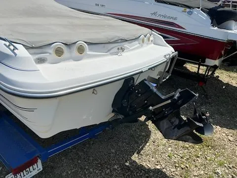 Slide: The Image of 2006 Larson 180 Bowrider SEI boat on trailer, covered, with visible outboard motor. - 2