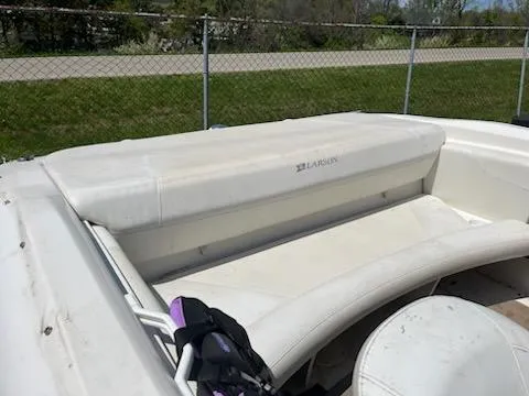 Slide: The Image of 2006 Larson 180 Bowrider SEI boat interior with white seating and outdoor setting. - 4