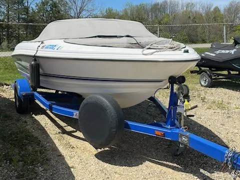Slide: The Image of 2006 Larson 180 Bowrider SEI on blue trailer, covered, parked outdoors. - 8