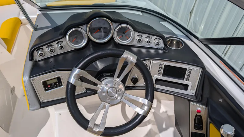 Slide: The Image of 2013 MasterCraft X2 boat dashboard with steering wheel and gauges. - 12
