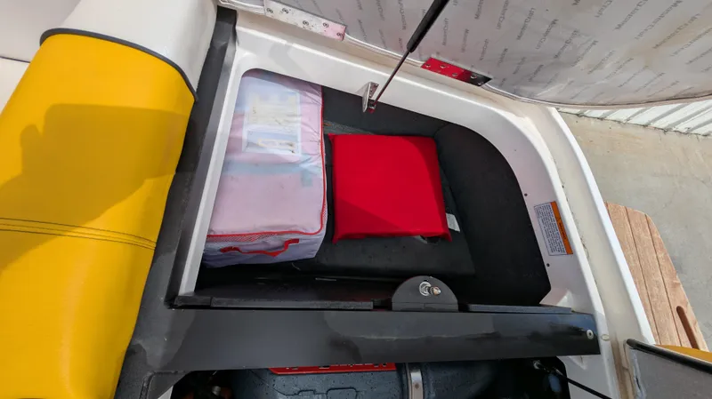Slide: The Image of Storage compartment in a 2013 MasterCraft X2 boat with safety equipment. - 23