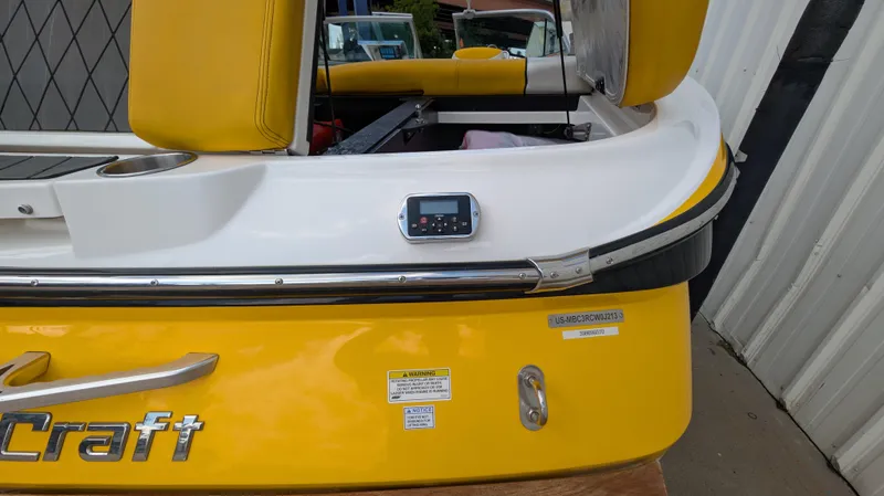 Slide: The Image of 2013 MasterCraft X2 boat, yellow and white exterior, rear view with seating and control panel. - 31