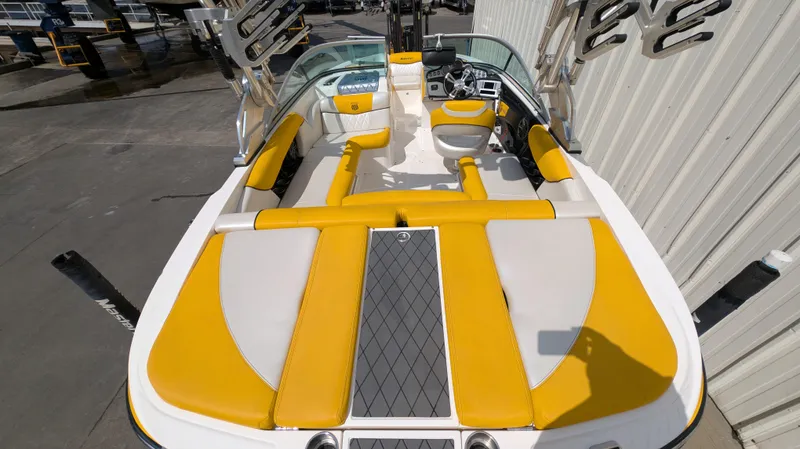 Slide: The Image of 2013 MasterCraft X2 boat interior with yellow and white seating, docked beside a building. - 6