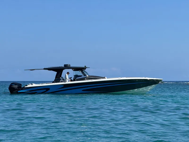 Slide: The Image of 2022 Nor-Tech 450 Sport Center Console boat cruising on clear blue water. - 0