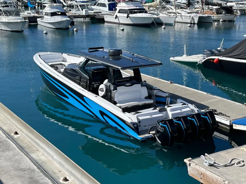 Slide: The Image of 2022 Nor-Tech 450 Sport Center Console boat docked in a marina with multiple engines. - 14