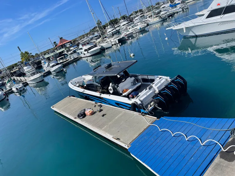 Slide: The Image of 2022 Nor-Tech 450 Sport Center Console docked in a marina with clear blue water. - 17