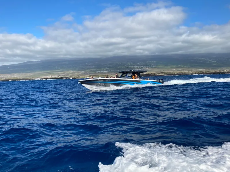 Slide: The Image of 2022 Nor-Tech 450 Sport Center Console cruising on open blue ocean waters. - 2