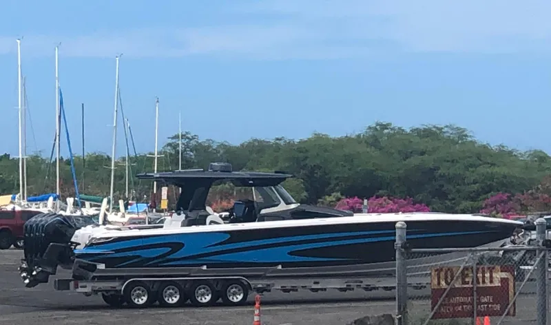 Slide: The Image of 2022 Nor-Tech 450 Sport Center Console boat on trailer, blue and black design. - 21