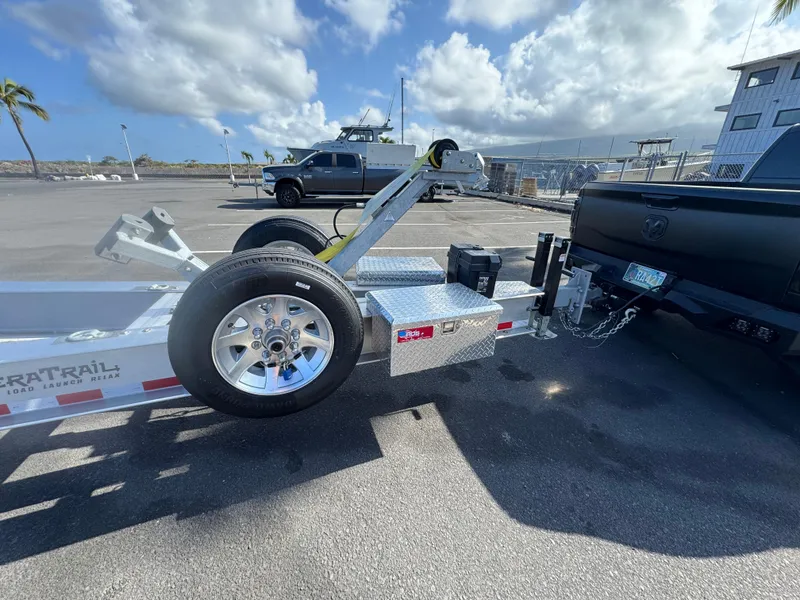 Slide: The Image of Trailer hitched to a truck, parked near a marina under a cloudy sky. - 24
