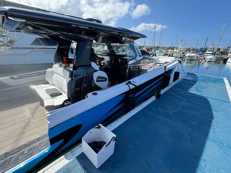 Slide: The Image of 2022 Nor-Tech 450 Sport Center Console docked at marina under blue sky. - 6