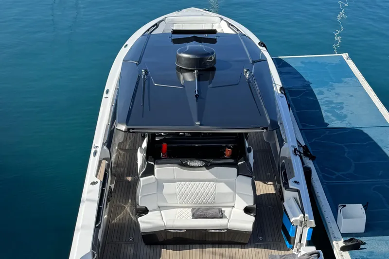 Slide: The Image of 2022 Nor-Tech 450 Sport Center Console boat docked on calm water. - 7