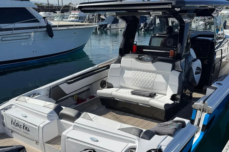 Slide: The Image of 2022 Nor-Tech 450 Sport Center Console boat docked, featuring luxurious seating and modern design. - 8