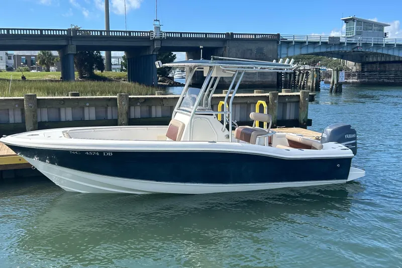 The Image of 2005 Scout 205 Sportfish boat docked near a bridge on a sunny day. - 0
