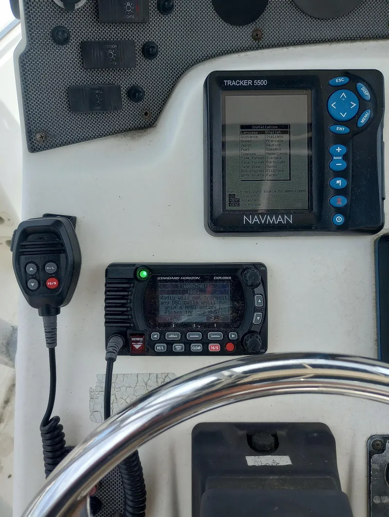 Slide: The Image of 2005 Scout 205 Sportfish boat dashboard with steering wheel and controls. - 13