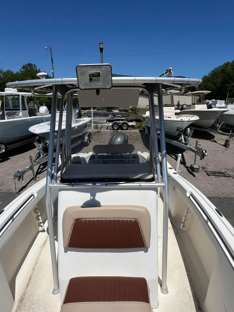 Slide: The Image of 2005 Scout 205 Sportfish boat with brown and beige seating in a marina. - 5