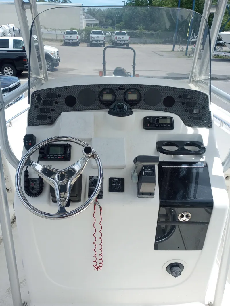 Slide: The Image of 2005 Scout 205 Sportfish boat with seating and motor, parked on gravel lot. - 8