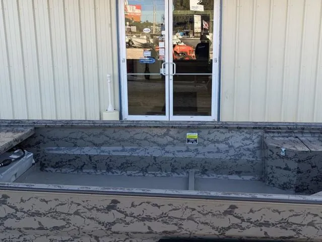 Slide: The Image of 2025 Gator Tail 1754 Extreme Series boat with camouflage design near a building entrance. - 7