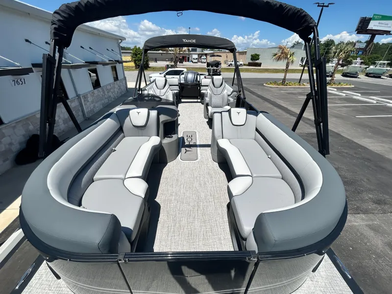Slide: The Image of 2025 Tahoe LTZ QL25T pontoon boat with spacious seating and canopy, parked outdoors. - 10