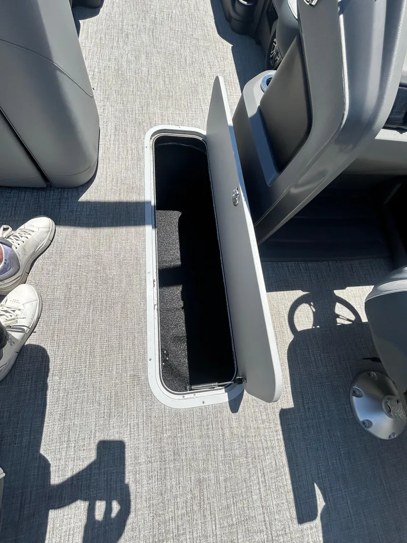 Slide: The Image of Open storage compartment on 2025 Tahoe LTZ QL25T boat with gray flooring. - 15