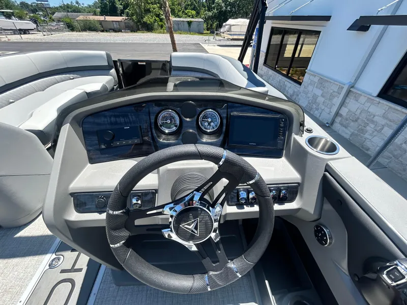 Slide: The Image of 2025 Tahoe LTZ QL25T boat dashboard with steering wheel and gauges. - 16