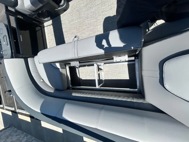 Slide: The Image of 2025 Tahoe LTZ QL25T boat interior with open storage compartment and gray seating. - 17