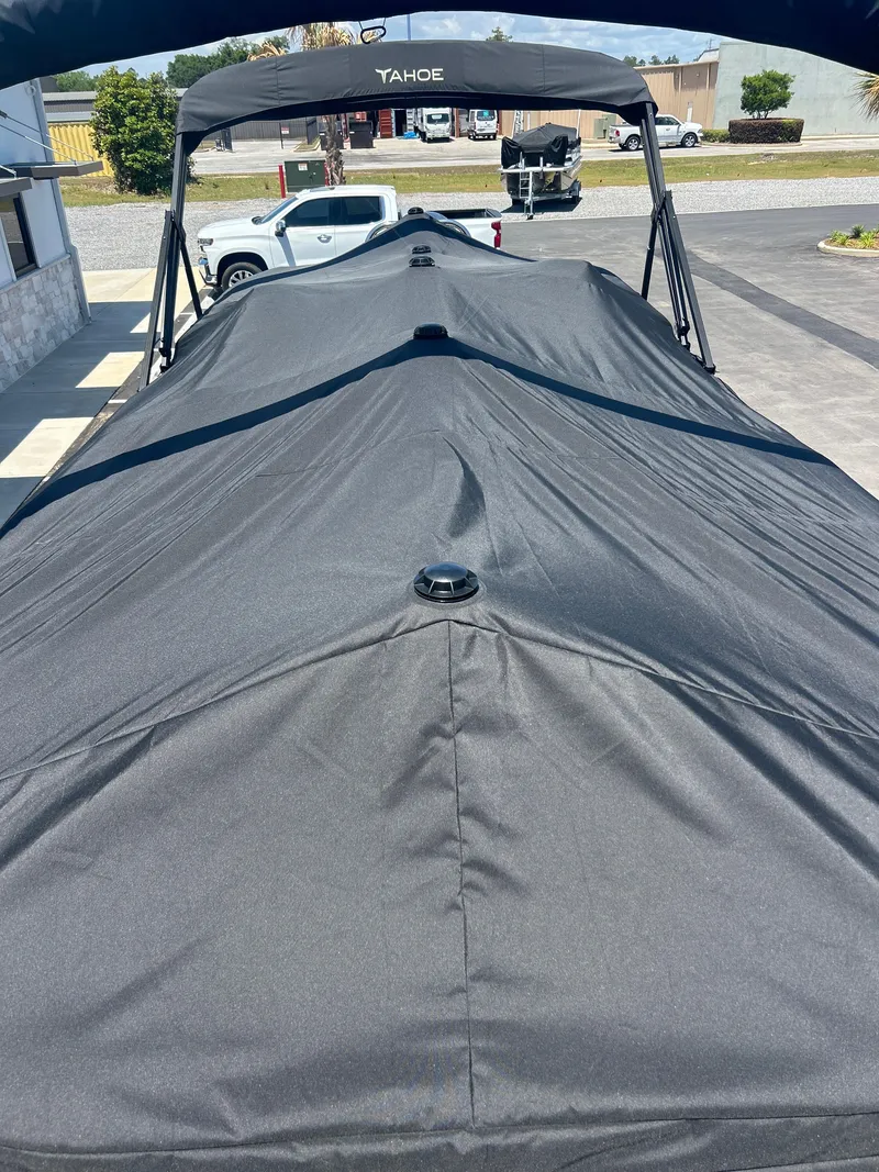 Slide: The Image of 2025 Tahoe LTZ QL25T boat with black cover in a parking area. - 20