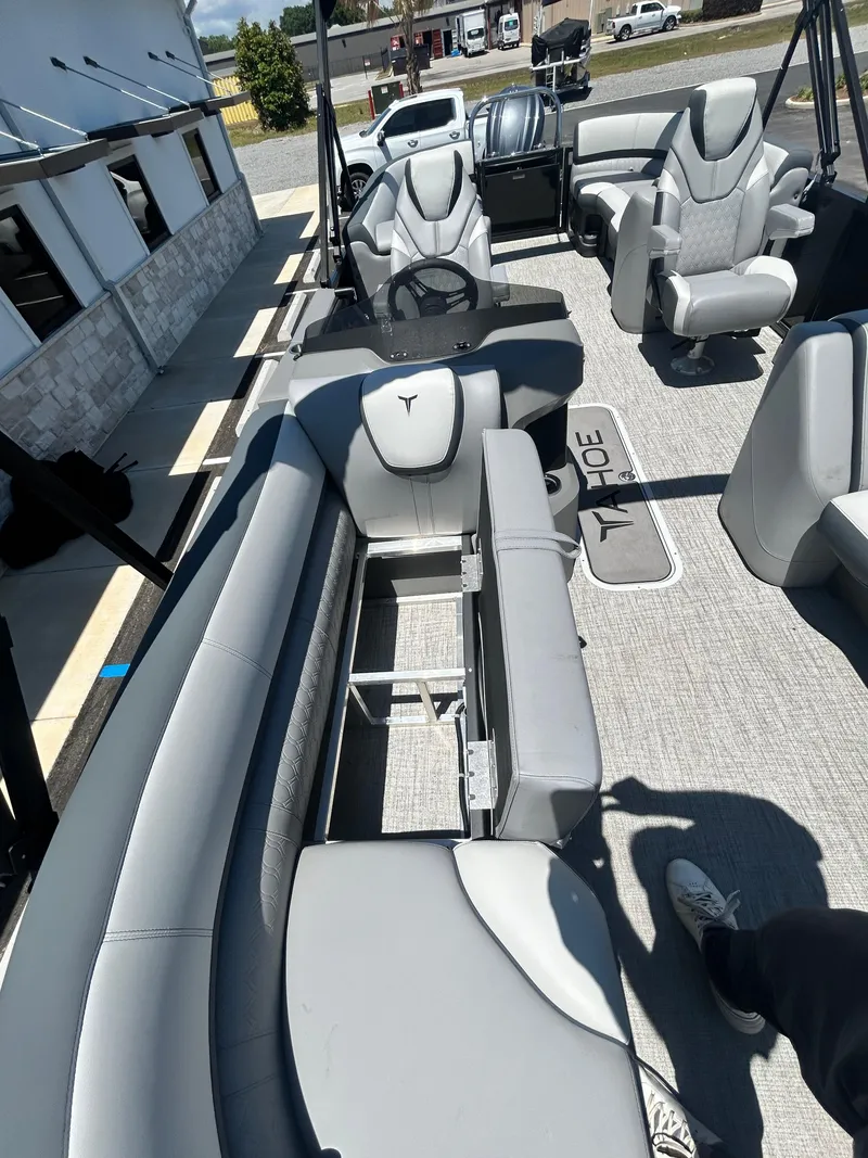 Slide: The Image of 2025 Tahoe LTZ QL25T boat interior with gray seating and open storage compartment. - 21