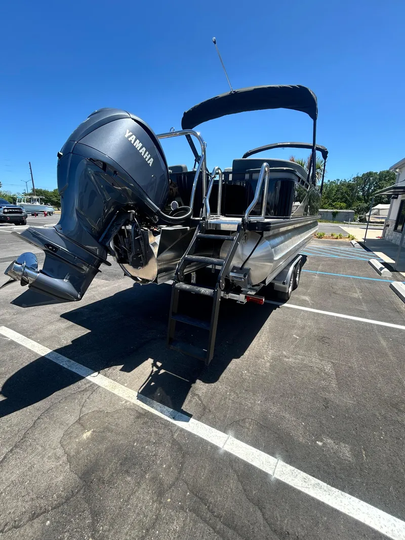 Slide: The Image of 2025 Tahoe LTZ QL25T pontoon boat with Yamaha outboard motor in parking lot. - 23