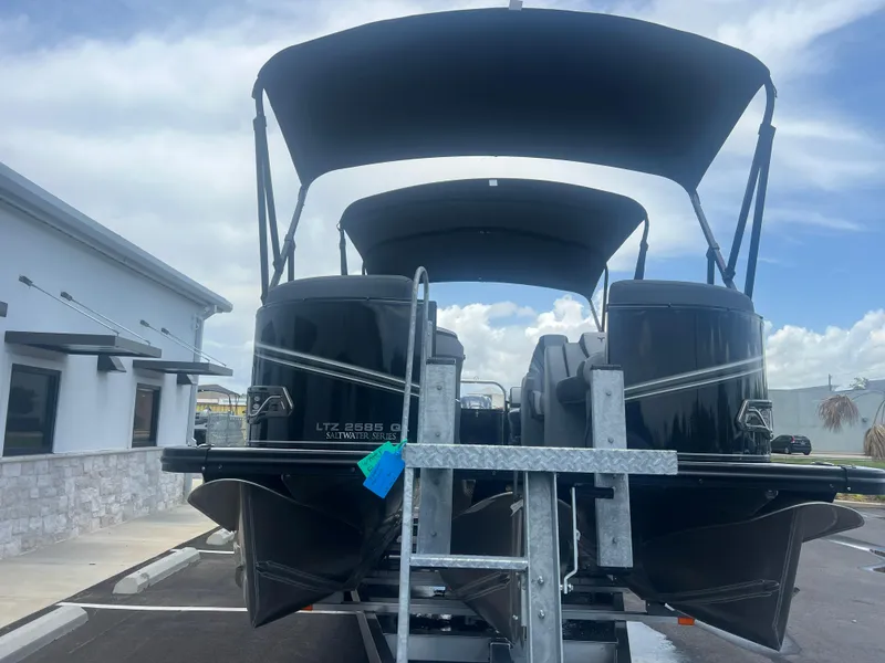 Slide: The Image of 2025 Tahoe LTZ QL25T pontoon boat on trailer, parked outdoors. - 28