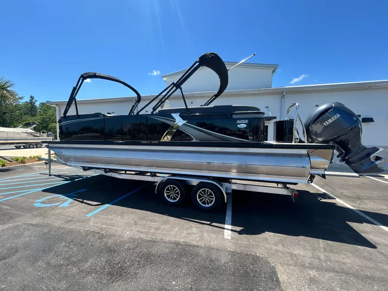 Slide: The Image of 2025 Tahoe LTZ QL25T pontoon boat on trailer, parked in sunny lot. - 3