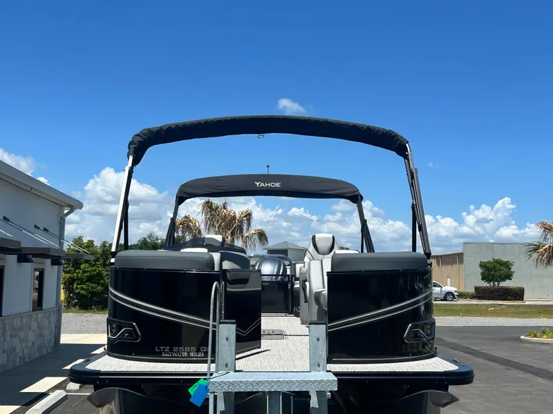 Slide: The Image of 2025 Tahoe LTZ QL25T pontoon boat with canopy, parked outdoors under clear blue sky. - 7